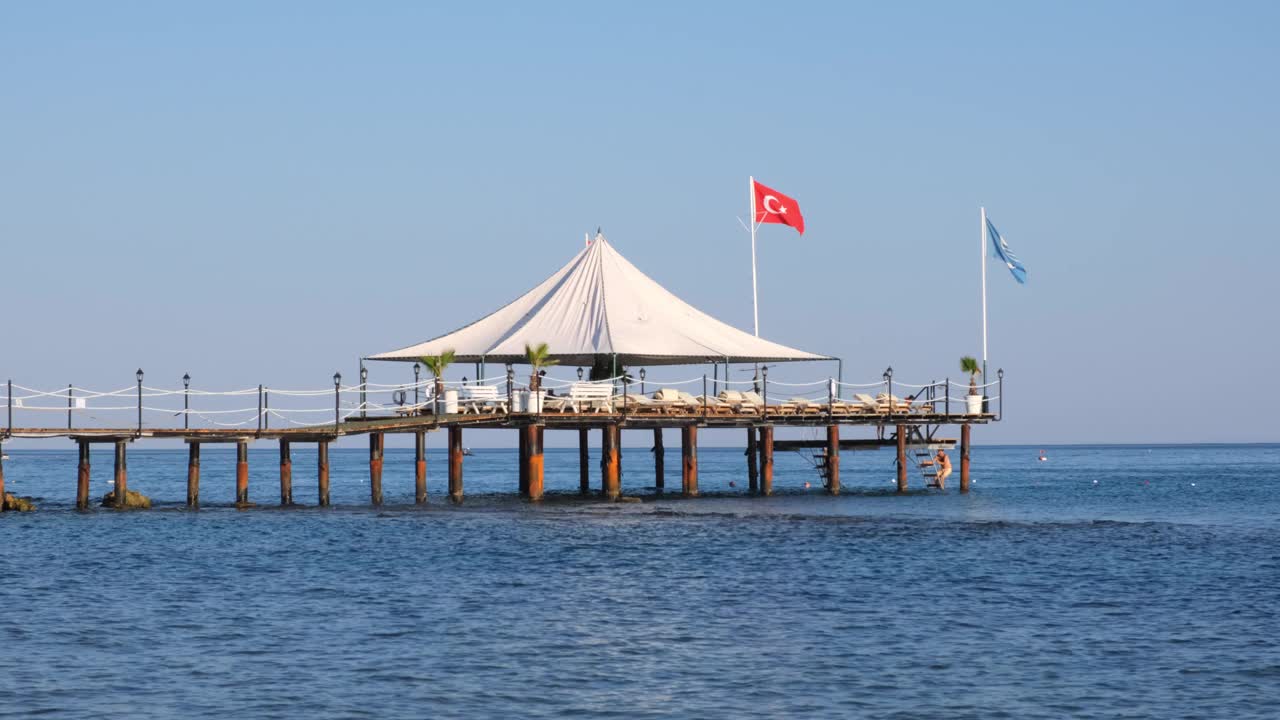 土耳其地中海边著名的旅游胜地塞德的卵石海滩和碧海碧水上的小木墩视频素材