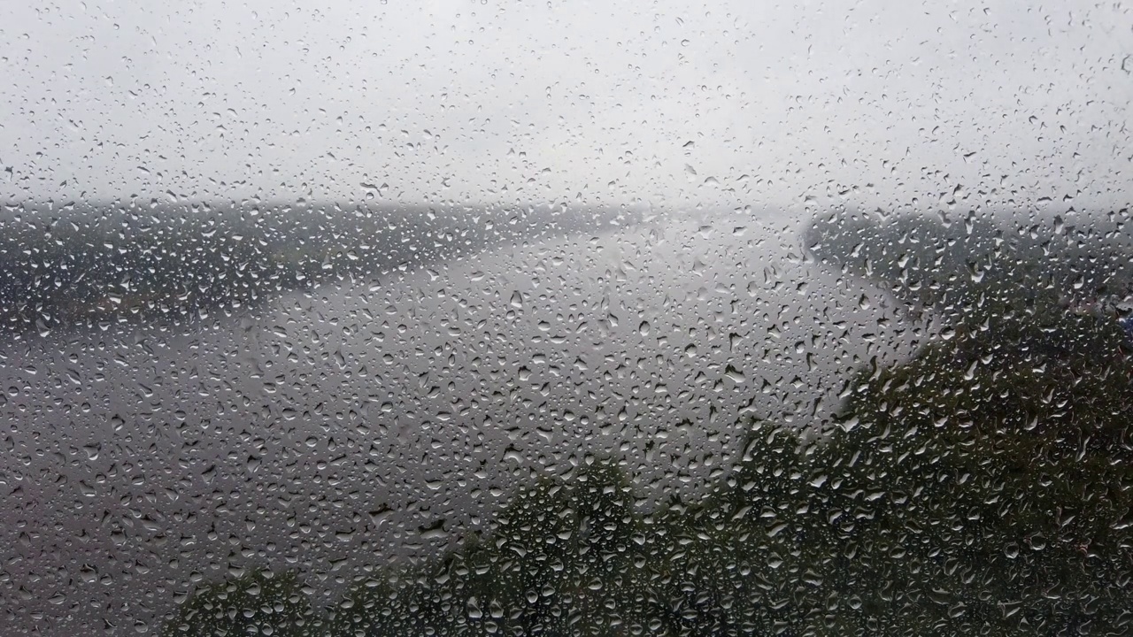 雨滴落在窗户上。多雨的天气。河流在背景上流动视频素材