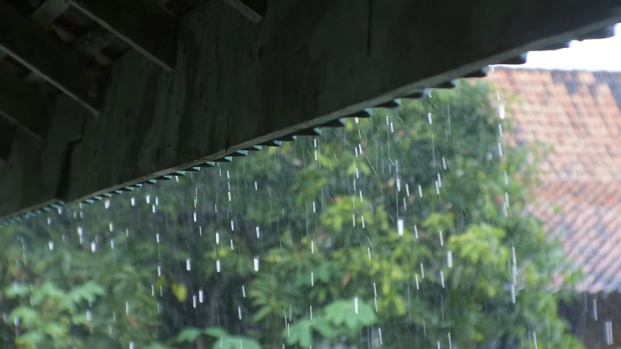 雨水从屋顶滴落下来。乡下倾盆大雨。潮湿的气候。雨滴从木质顶棚上落下高清视频视频素材