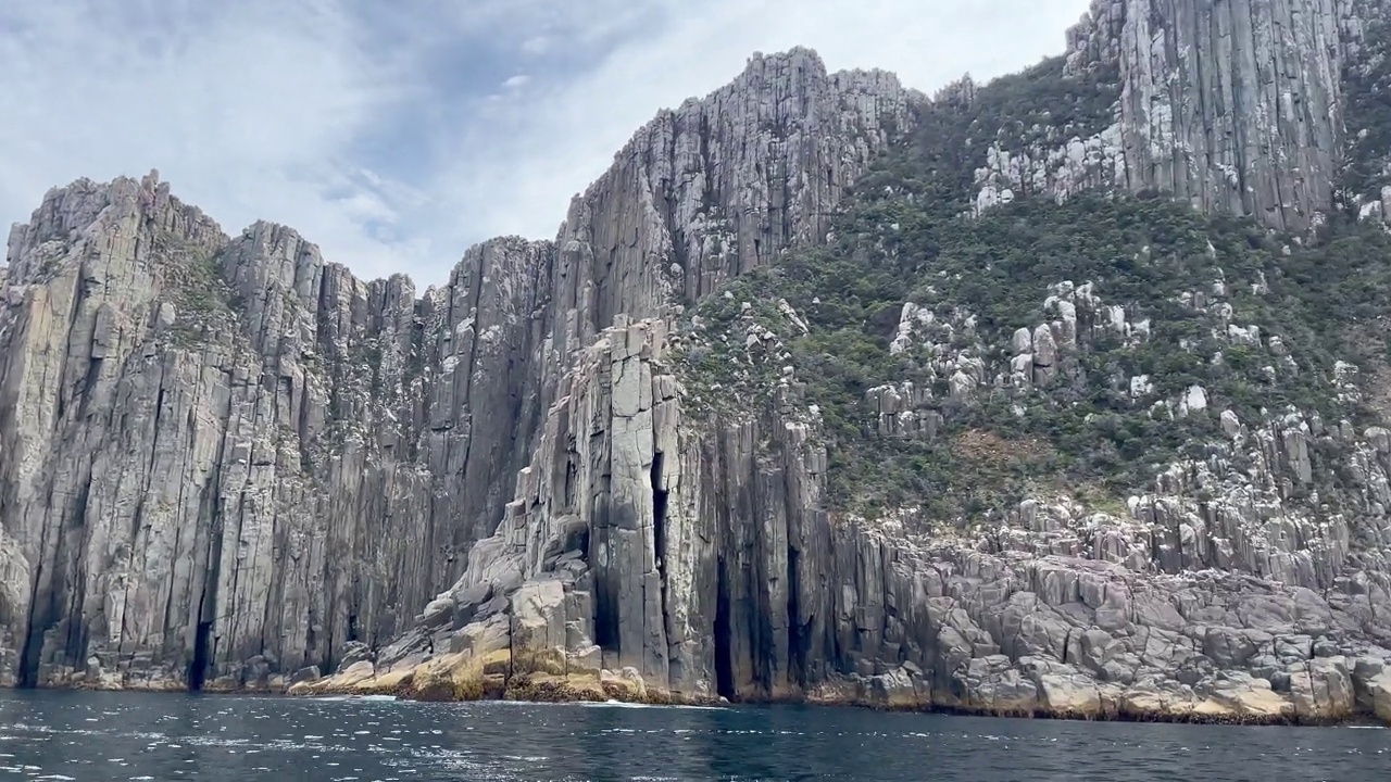 多岩的塔斯马尼亚海岸线，高耸的海崖，移动的船景视频素材