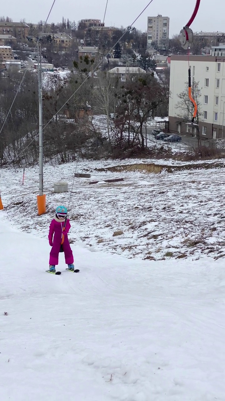 那孩子借助滑雪缆车滑上斜坡。视频素材