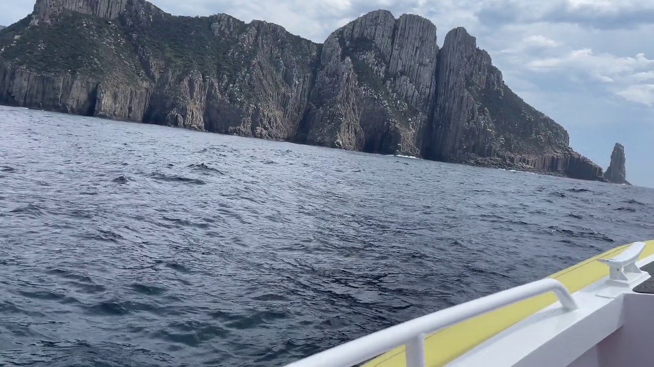 波涛汹涌的大海，波涛汹涌的海浪，岩石林立的海岸线，游船观光视频素材