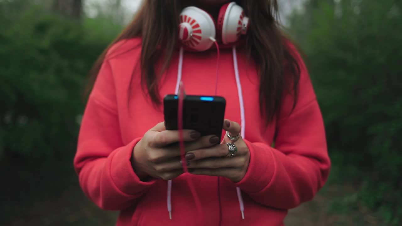 一个年轻的女人若有所思地用耳机打电话。臂拍摄视频素材