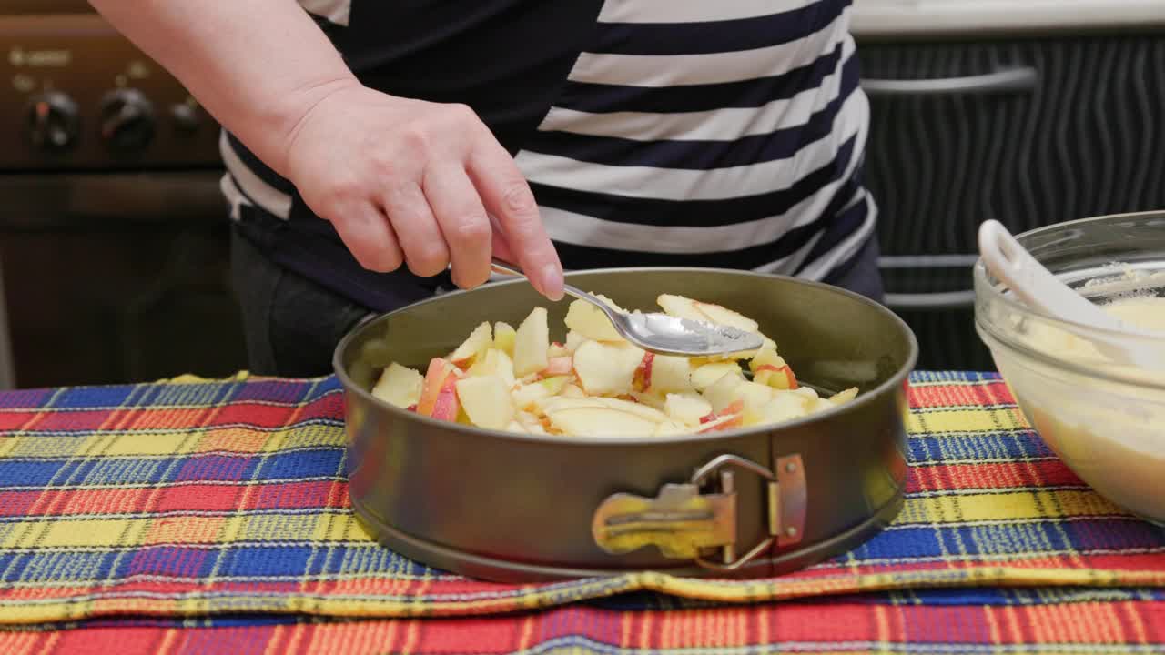 在做苹果派的时候，女士先生把苹果铺成烘烤状，然后把甜面团倒进去视频素材