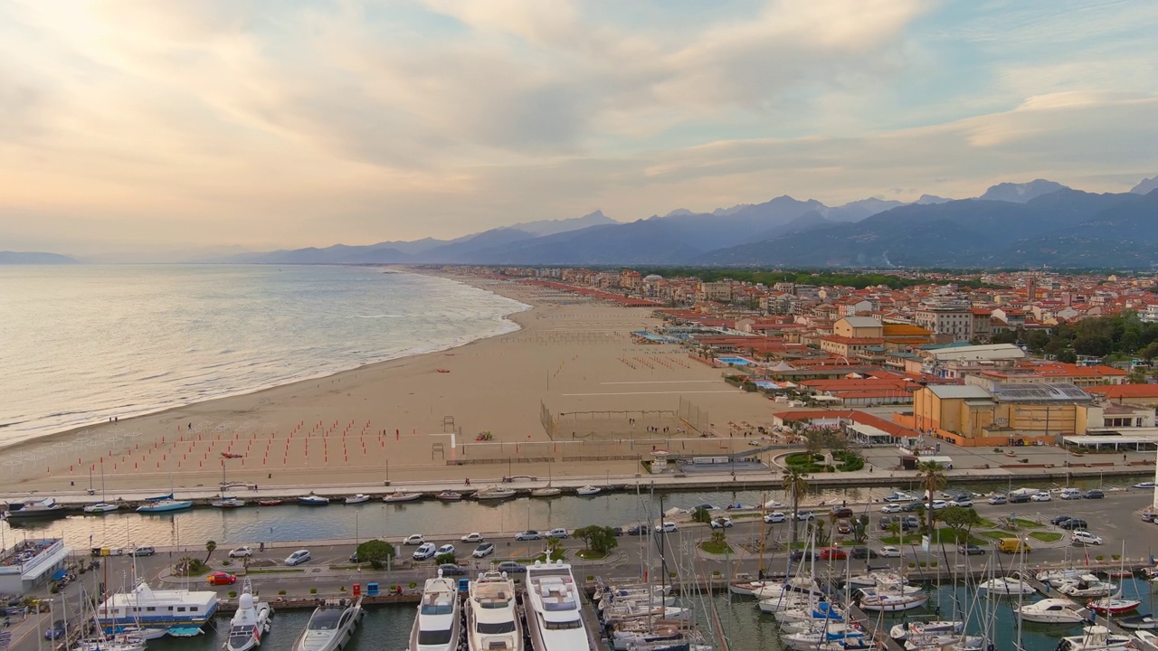 意大利，Viareggio——托斯卡纳避暑胜地的鸟瞰图，日落时分的Apuan Riviera和Versilia的著名海滩的金色沙滩，多彩的天空——从空中俯瞰欧洲的景观全景——HDR视频素材