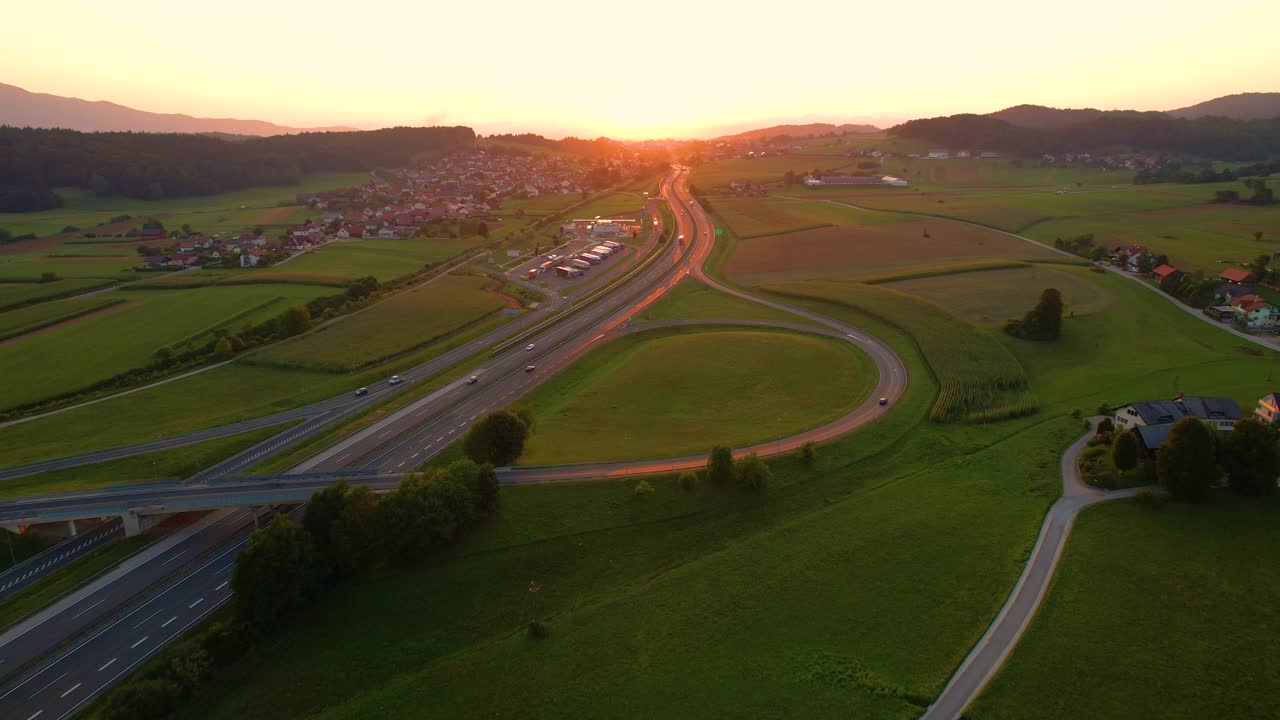 航拍:沿着繁忙的高速公路飞向绚丽的金色夕阳。视频素材