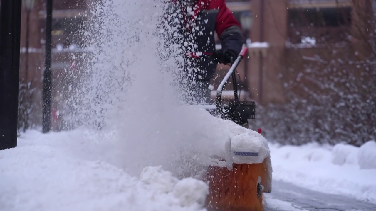 模糊扫雪机在冬季在大雪天气背景下清除道路上的积雪。视频素材