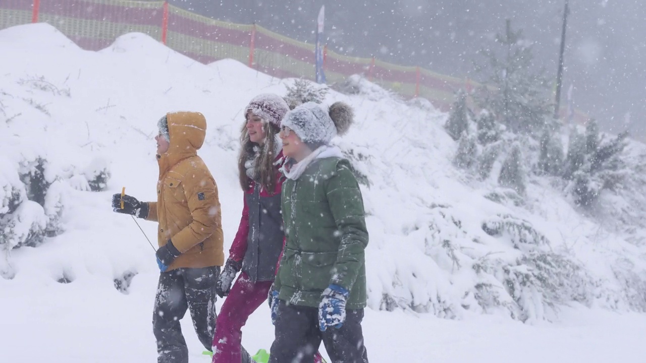 孩子们喜欢在暴风雪中玩雪橇视频素材