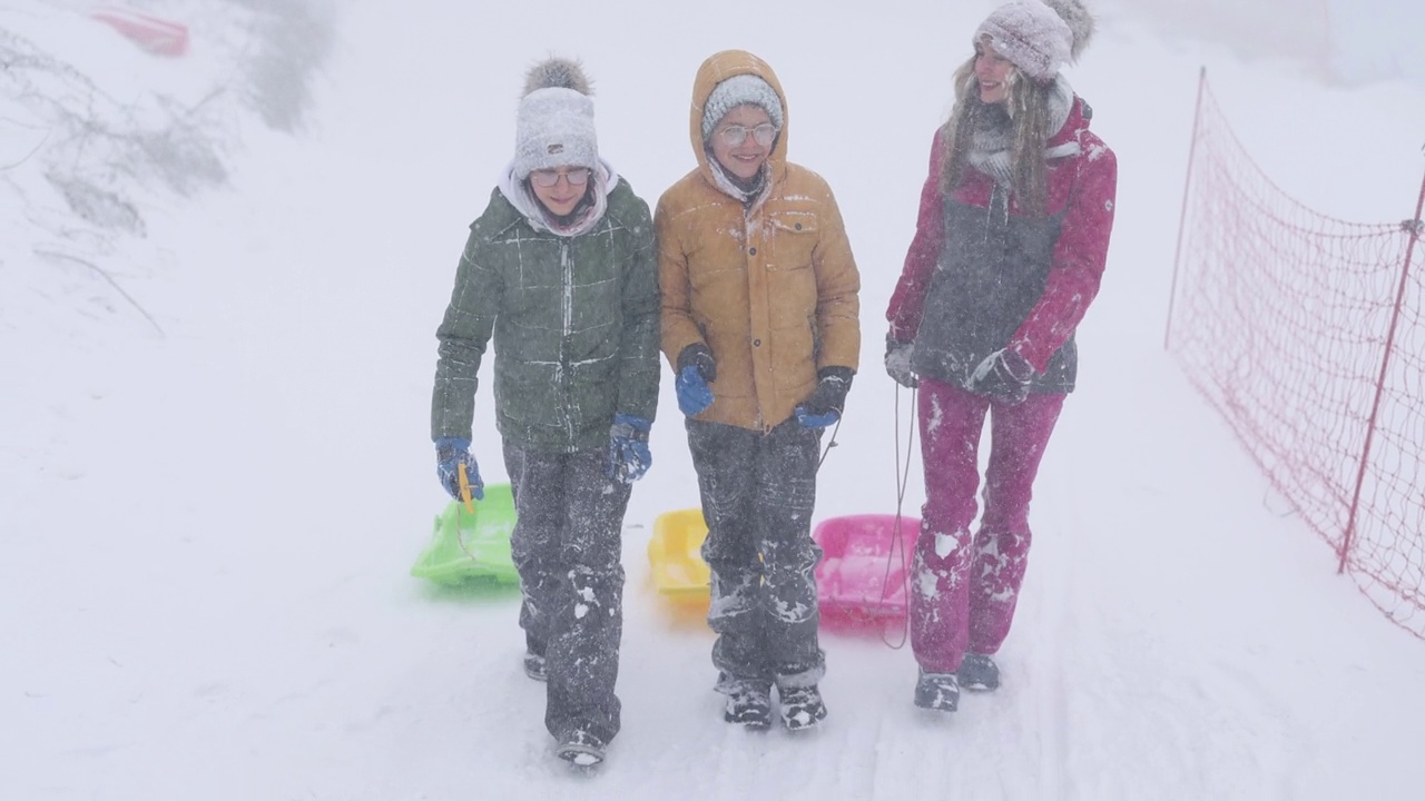 孩子们喜欢在暴风雪中玩雪橇视频素材