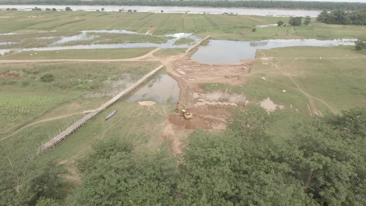 无人机拍摄的竹桥和开阔地的挖掘机视频素材