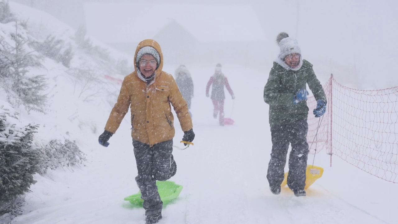 孩子们喜欢在暴风雪中玩雪橇视频素材