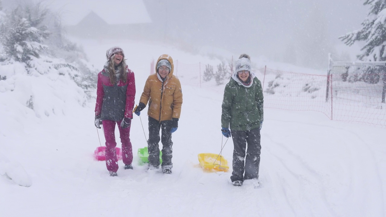 孩子们喜欢在暴风雪中玩雪橇视频素材