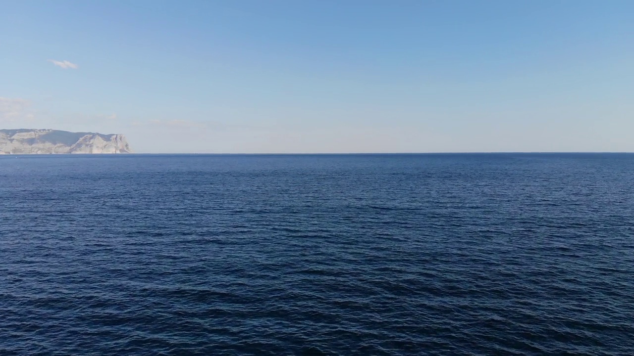 在以岩石海岸为背景的海面上的空中飞行。海洋背景视频素材