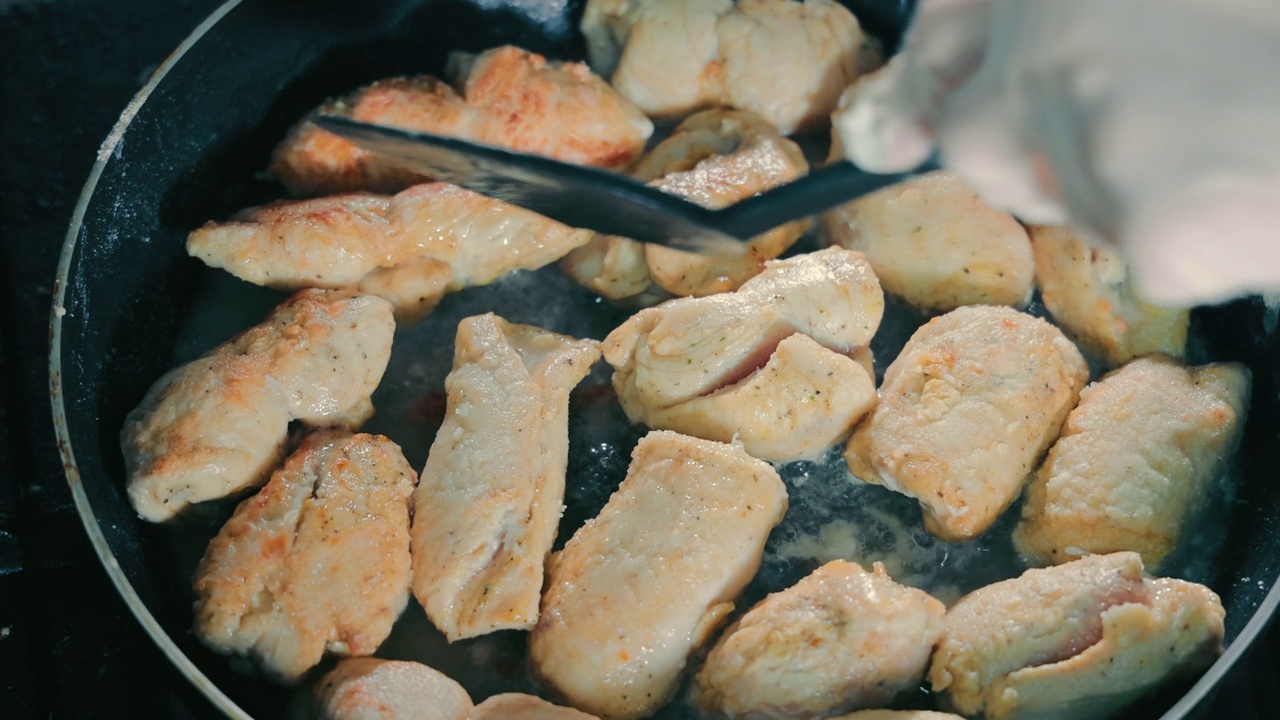 用油炸制鳕鱼片。烹饪街头小吃关闭。鱼片在油里炸，然后由厨师翻过来视频素材