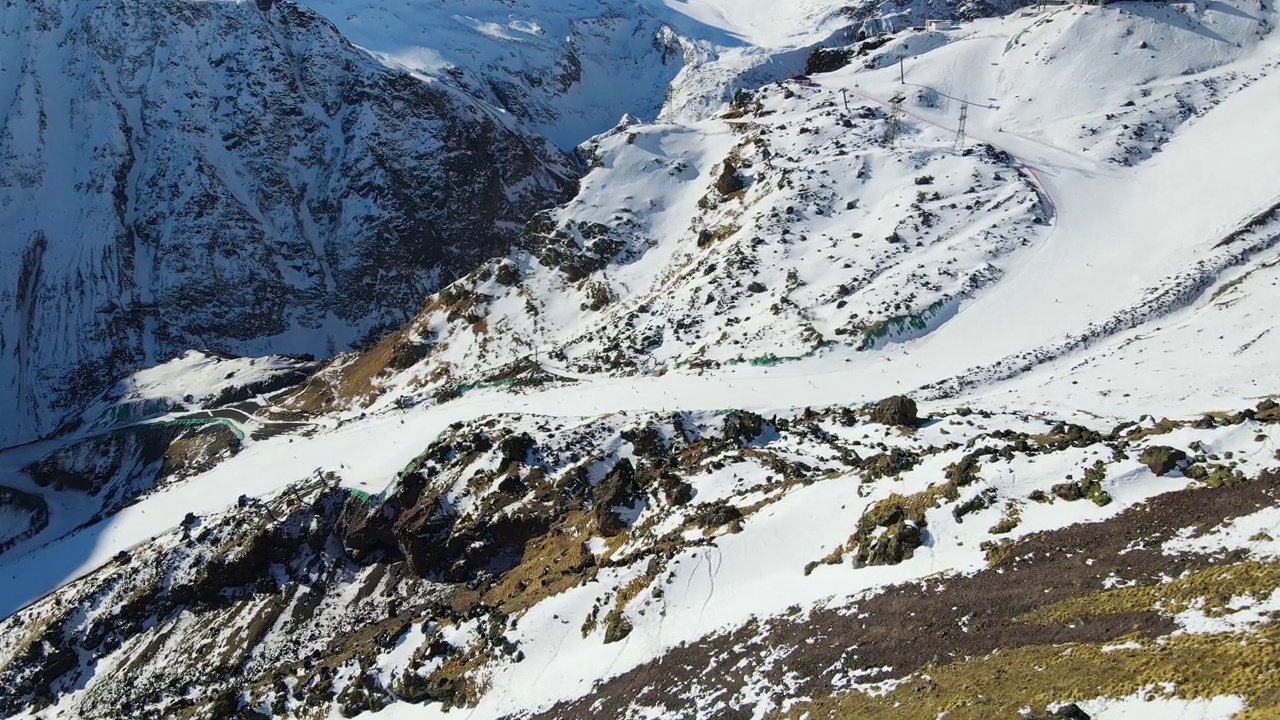 在厄尔布鲁斯山坡上的灰色岩石中与下坡滑雪者一起滑雪视频素材