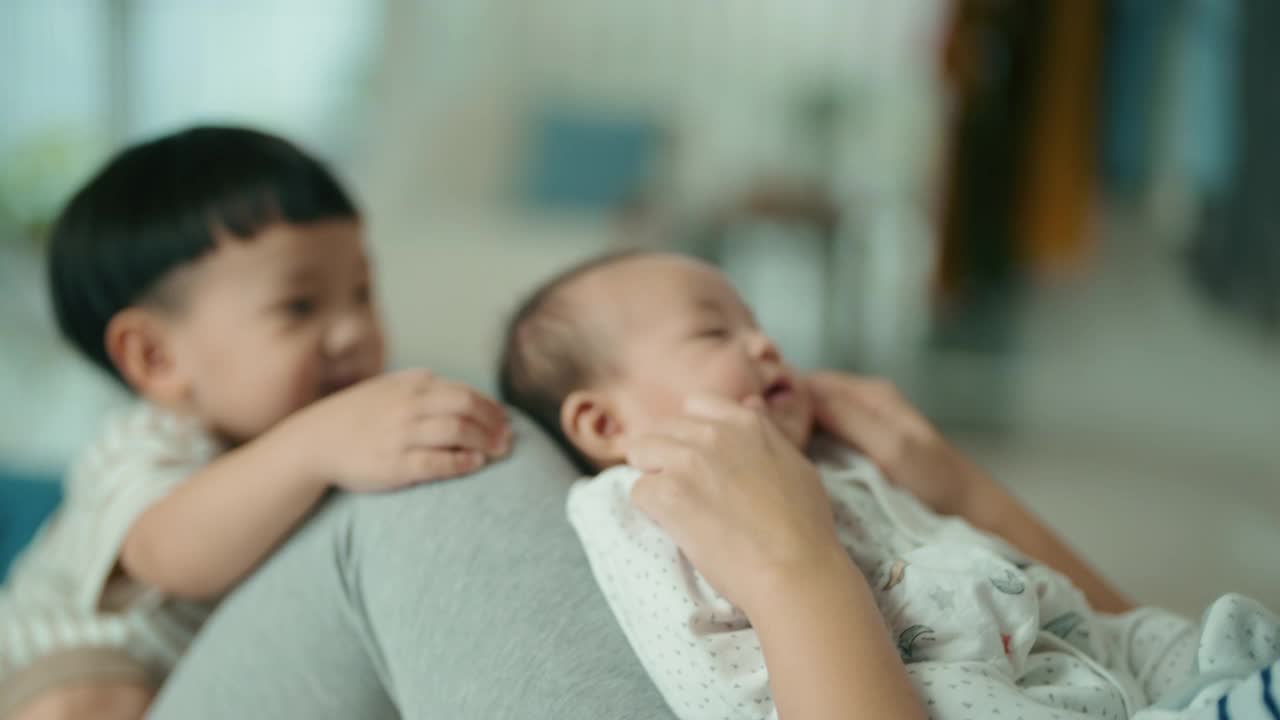 亚洲母亲在家里和她的两个刚学会走路的小男孩相处视频素材