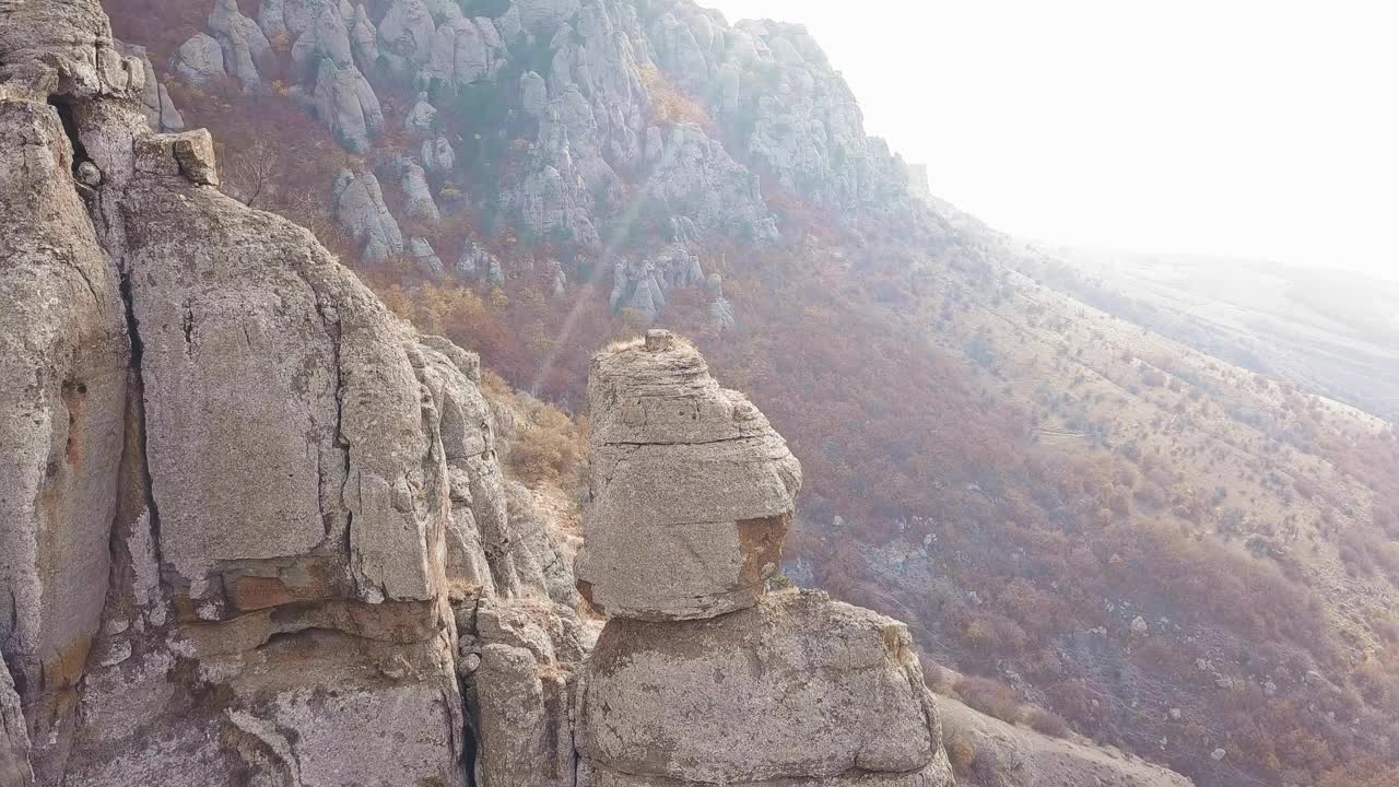 无人机缓慢地飞向岩石山顶在一个美丽的山景视频素材