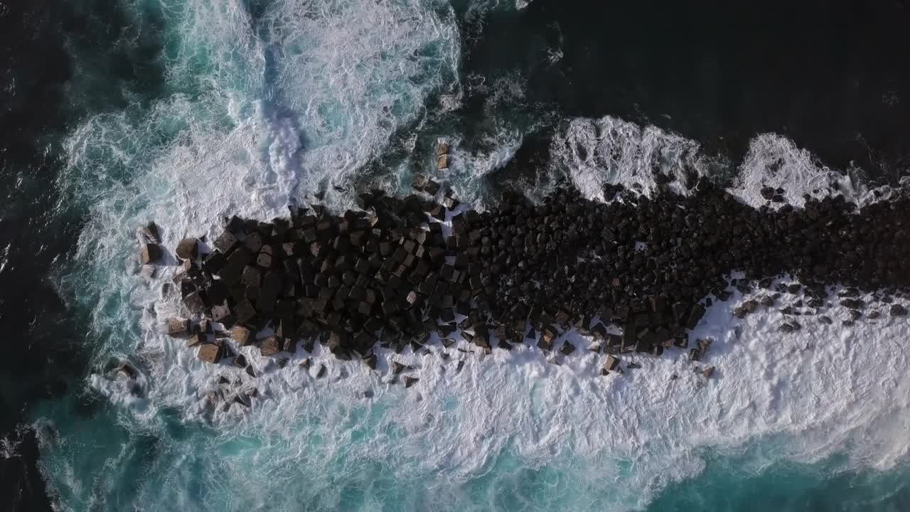 在西班牙加那利群岛的特内里费岛，海浪拍打在岩石上的鸟瞰图。视频下载