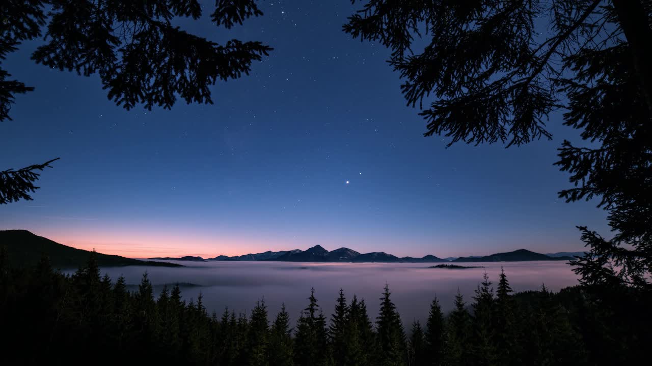 浪漫的蓝色星空与星星运动在森林山脉雾谷野生天文景观时间间隔4k视频素材