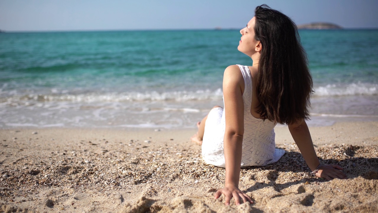 年轻女子在海滩上晒日光浴视频素材