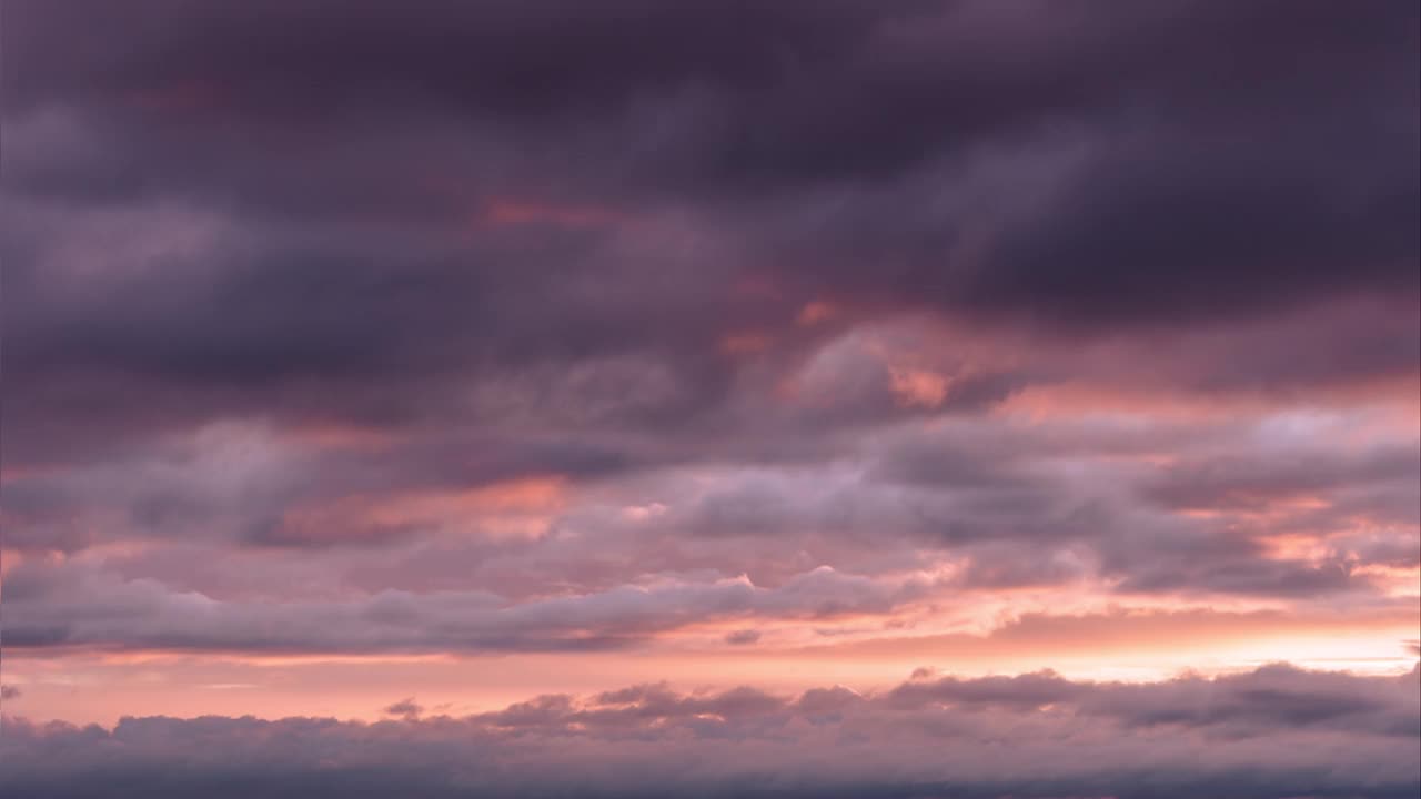 时间流逝。日落的天空。沉重的灰色和紫色的雨云移动在日落天空地平线上的橙色柔和的彩色效果。大自然。日出视频素材