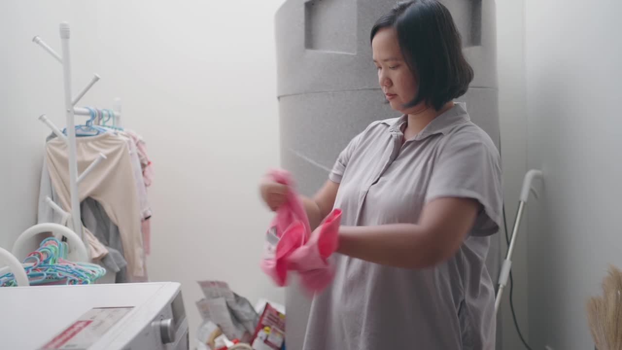 女人把洗过的湿衣服挂起来视频素材