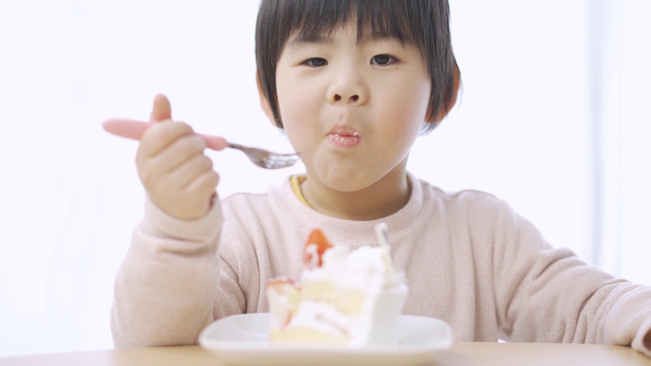 亚洲男孩笑着吃生日蛋糕视频素材