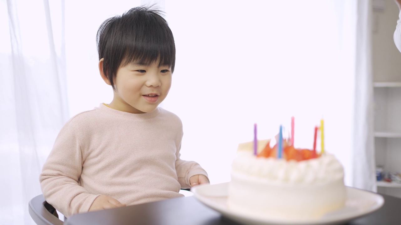 亚洲爸爸拿着一个用日语写着生日快乐的蛋糕视频下载