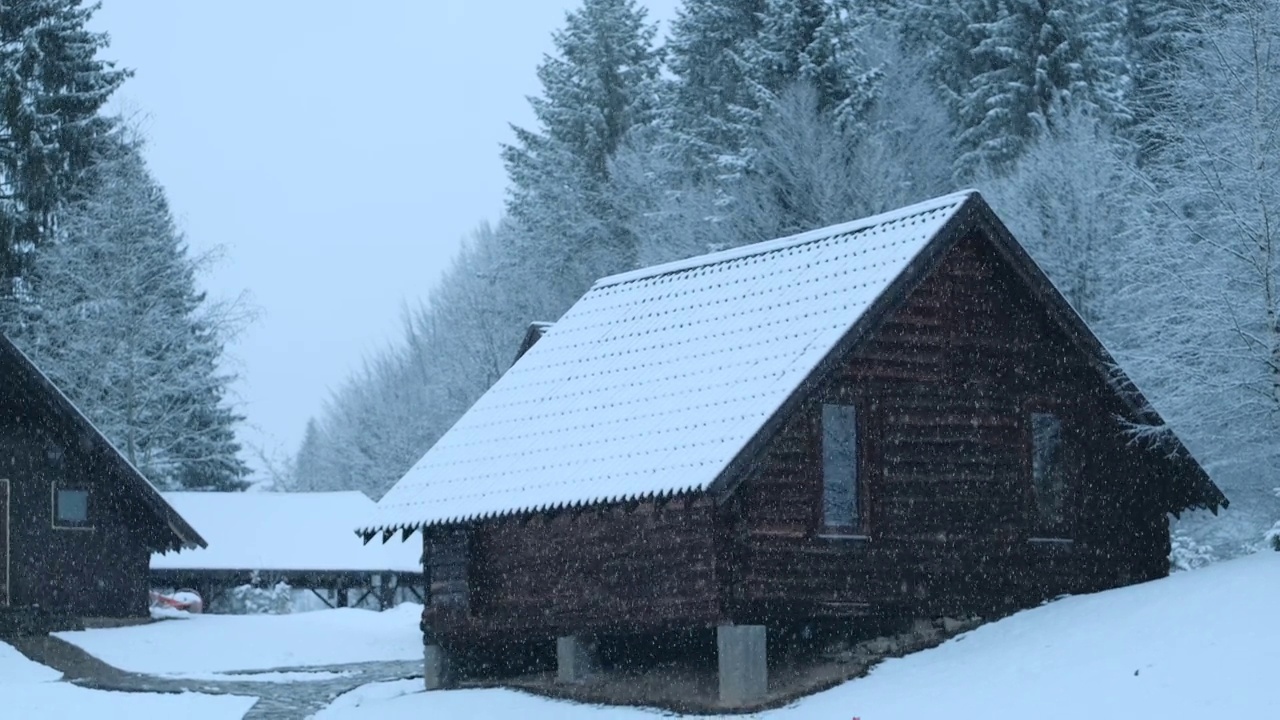 美丽的梦幻景观，在雪天的夜晚，森林里的木屋视频素材