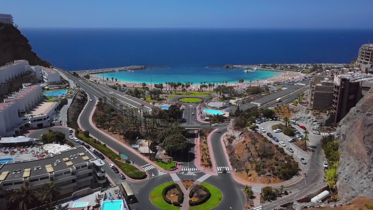 夏天飞行在阳光明媚的阿玛多雷斯海滩(Playa de Amadores)和蓝绿色的海，波多黎各de Gran Canaria，西班牙加那利群岛。从24帧每秒加速2.5倍。视频素材