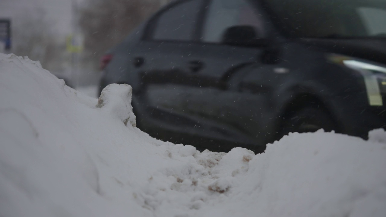 大雪期间的城市道路。汽车在冬天的泥和雪中行驶视频素材