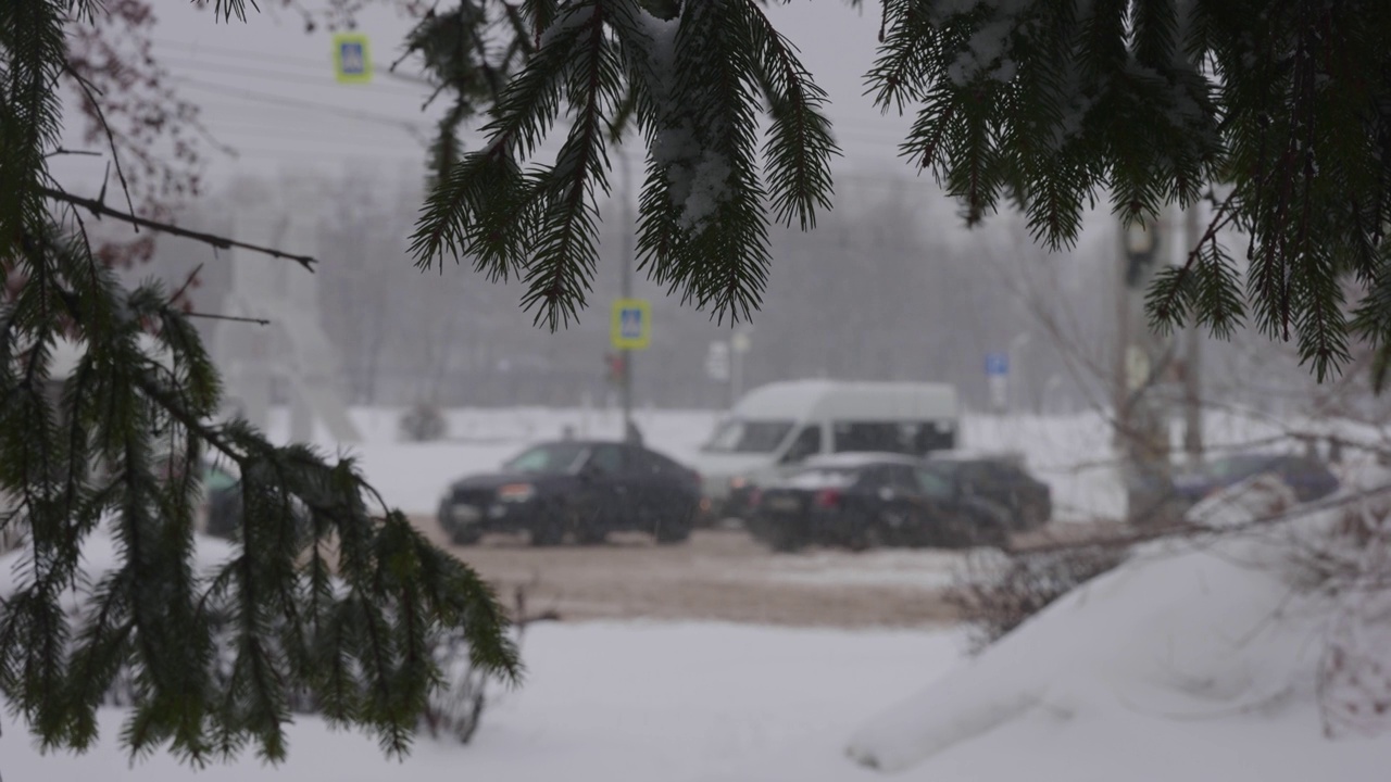 城市里下了大雪。十字路口的汽车在雪地里打滑视频素材