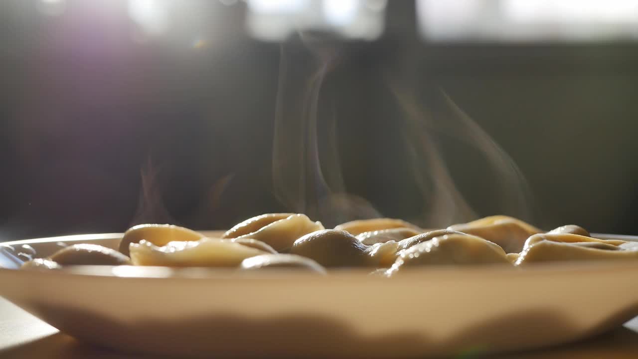 桌上有一碗热腾腾的饺子。蒸汽从饺子中升起视频素材