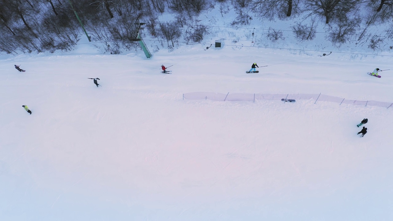 周末，滑雪者和单板滑雪者在滑雪坡道上滑雪。视频素材