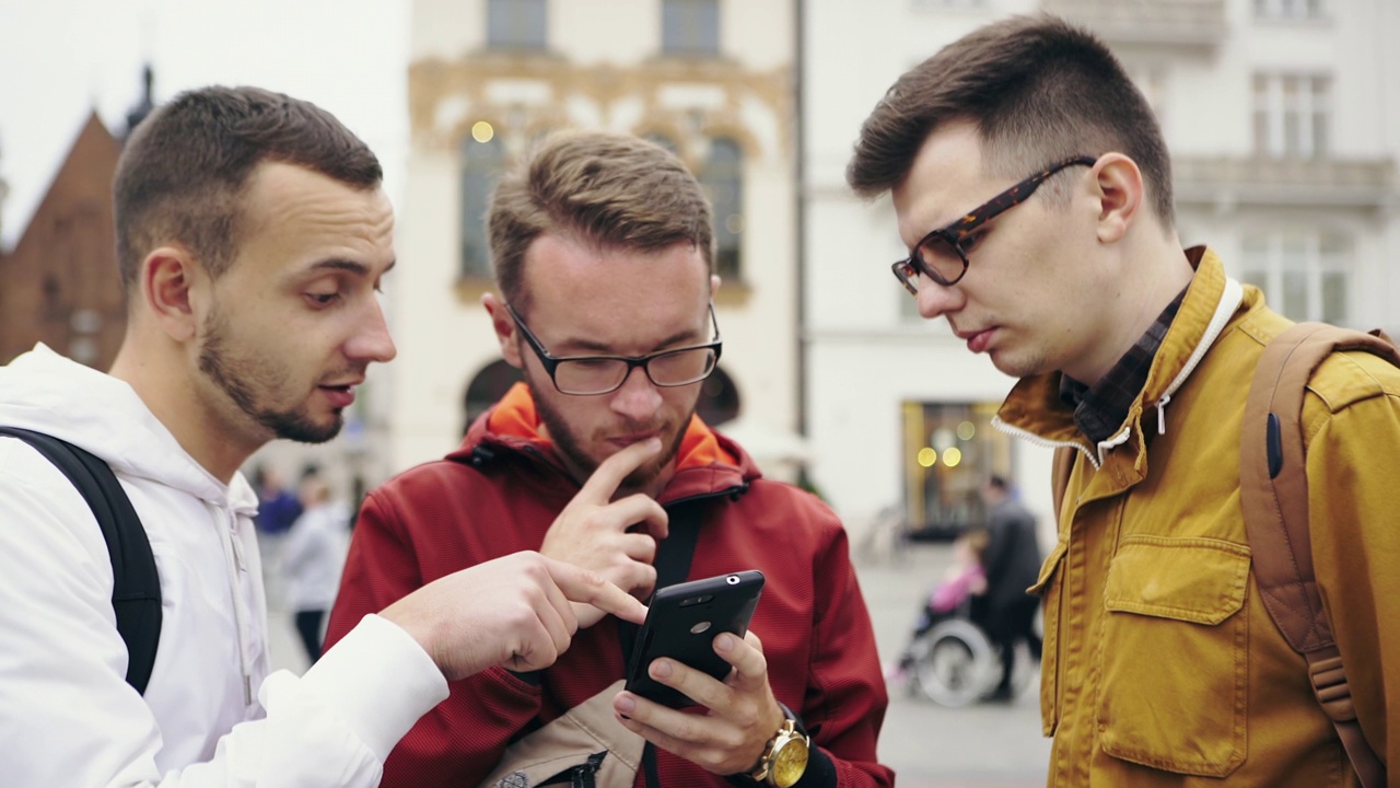 三个男人在智能手机上讨论城市地图视频下载