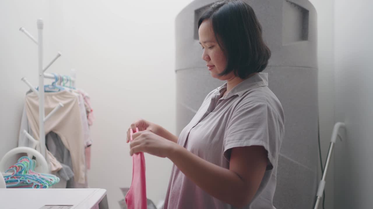 妇女在洗完衣服后挂湿衣服视频素材