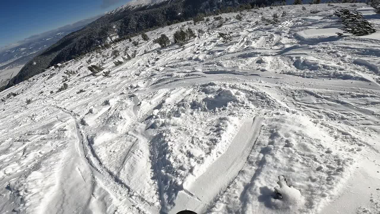 男子在一个阳光明媚的日子里在一个滑雪场的滑雪坡上滑雪视频素材