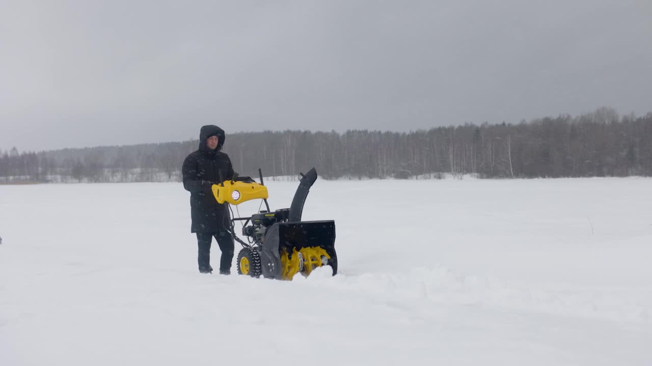 冬天，人们用犁铲雪。侧视图。慢动作视频素材