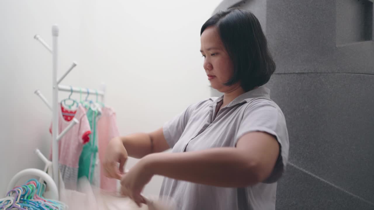 妇女在洗完衣服后挂湿衣服视频素材