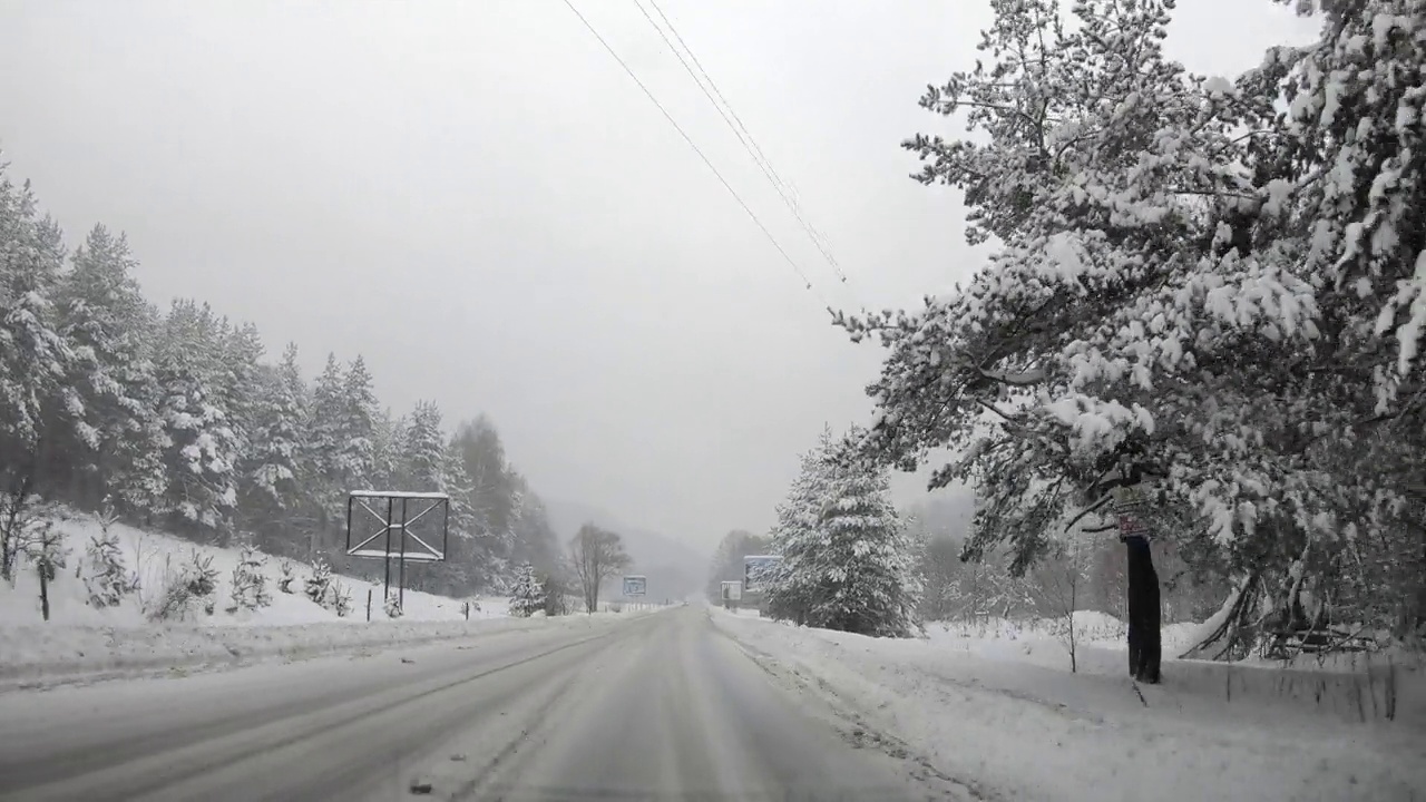 汽车正行驶在冬天暴风雪的道路上，POV视频素材