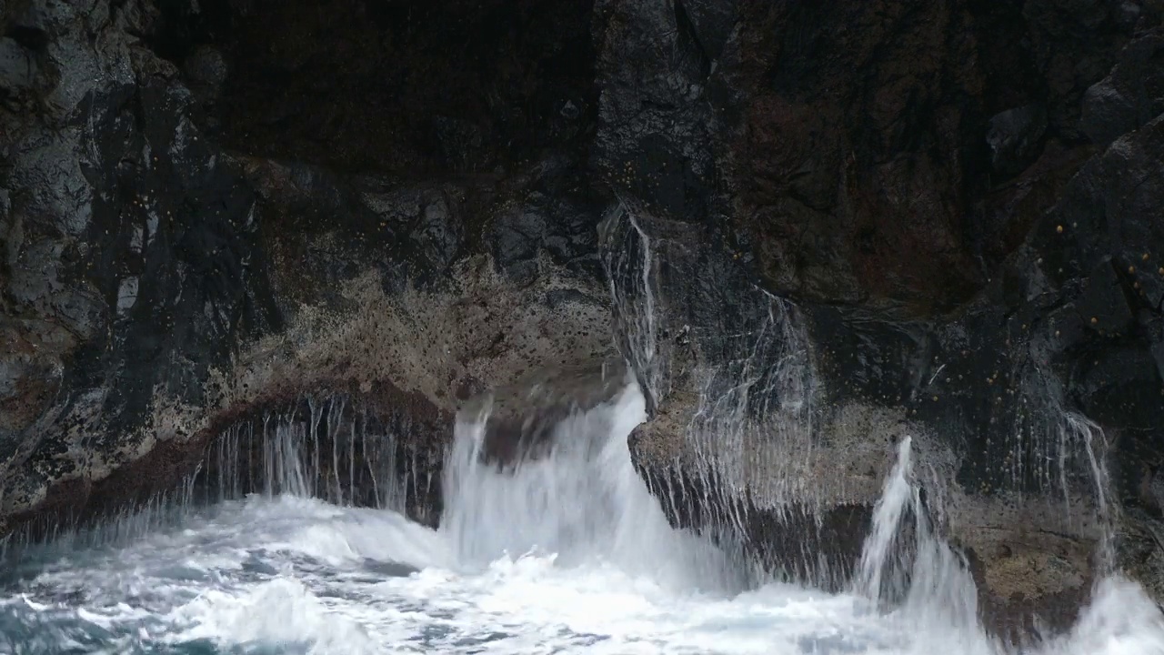 巨浪冲击着熔岩悬崖。视频素材