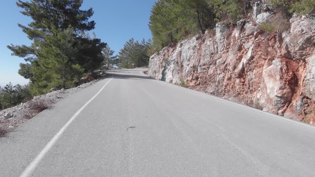 空旷的山路穿过岩石山丘和绿色的森林。在乡村旅行。柏油路风景优美视频素材