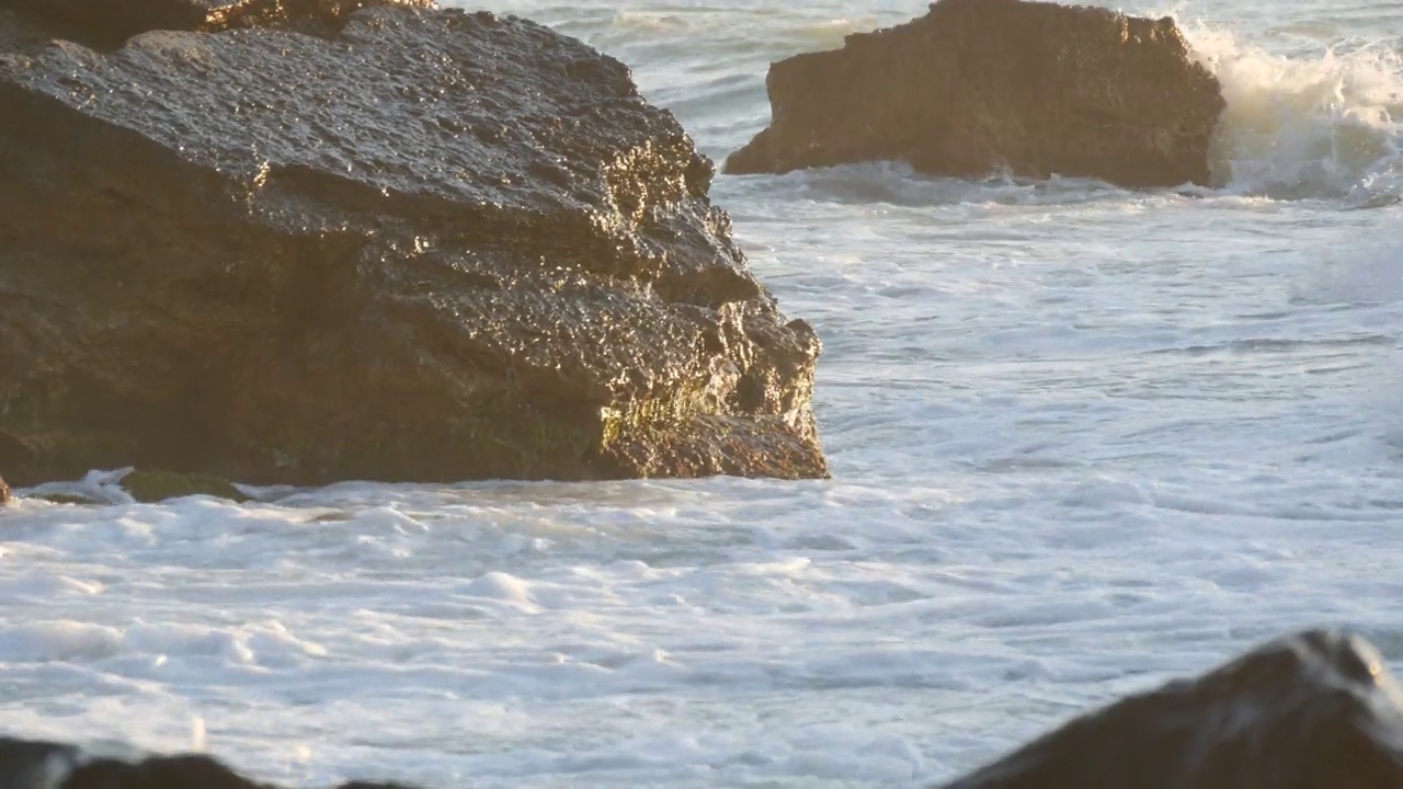 美丽的日落或日出在海上。巨浪撞向巨石。在海上风暴。大浪拍打着岩石海岸，水面上泛起白色的泡沫。黑海、保加利亚视频素材