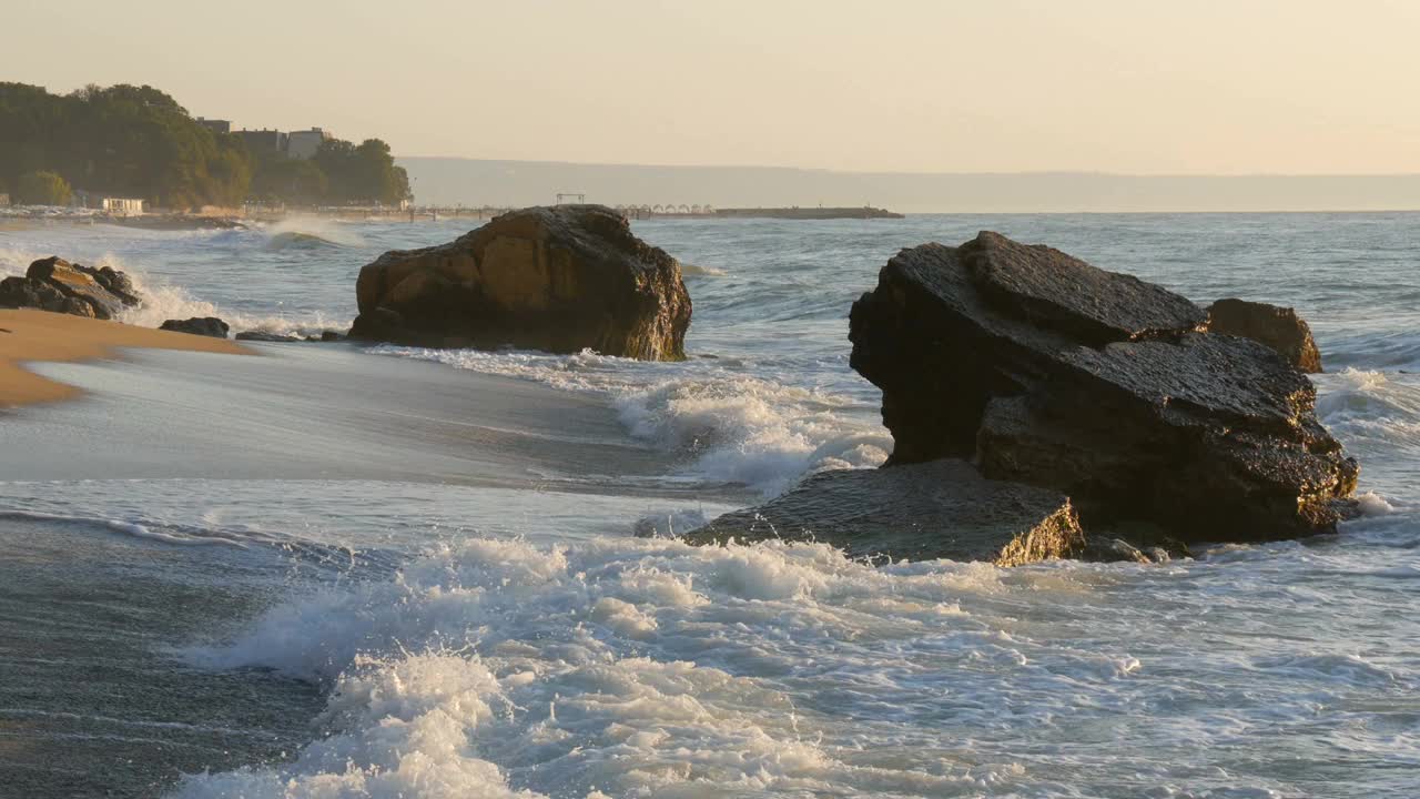 美丽的日落或日出在海上。巨浪撞向巨石。在海上风暴。大浪拍打着岩石海岸，水面上泛起白色的泡沫。黑海、保加利亚视频素材