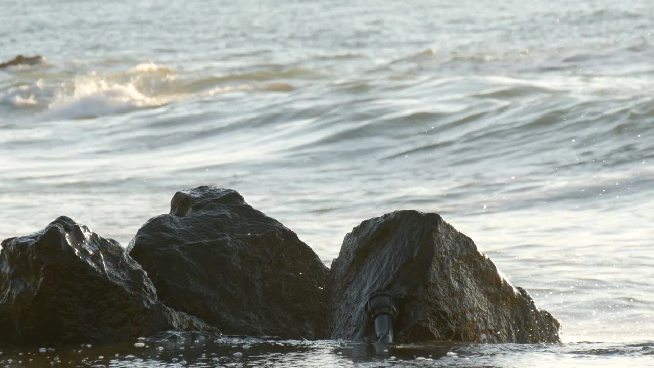 海滩上阳光灿烂的一天。大浪冲刷着保加利亚黑海的岩石海岸视频素材