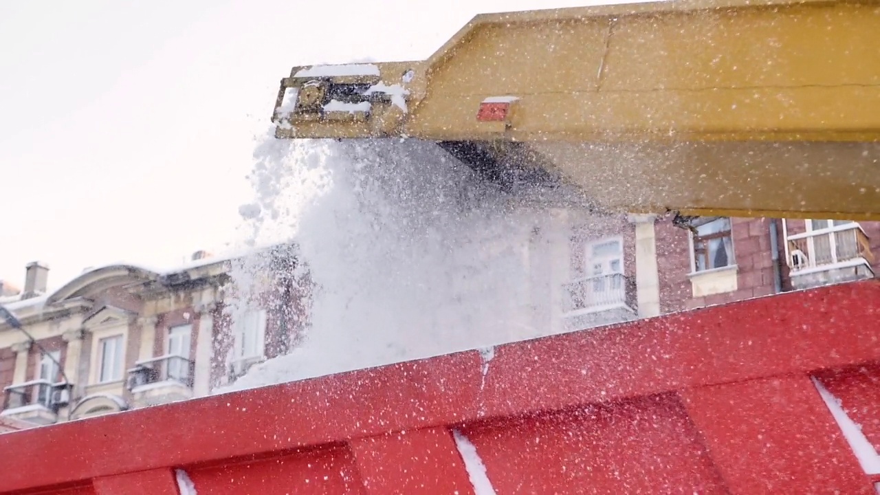 除雪拖拉机、抓斗装载机在自卸卡车上装载积雪堆。户外扫雪机在雨雪过后清扫街道或城市街道视频素材