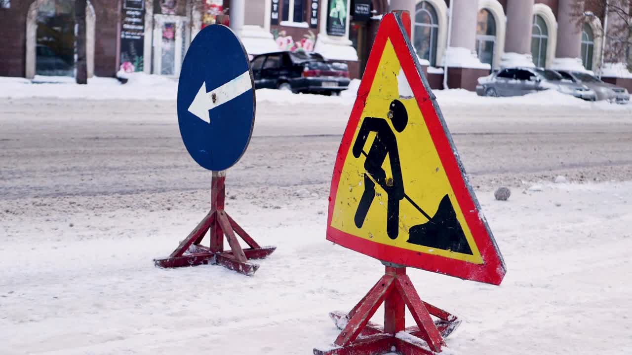 吹雪机清除结冰的冬季道路。扫雪机清除城市街道上的积雪。警告路标。冬季服务车辆吹雪机工作。清理积雪结冰的道路。视频素材