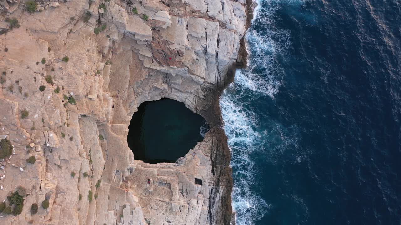 上图是地中海海滨附近的Giola天然泳池的鸟瞰图。海浪冲击着海岸线。Thassos岛,希腊视频下载