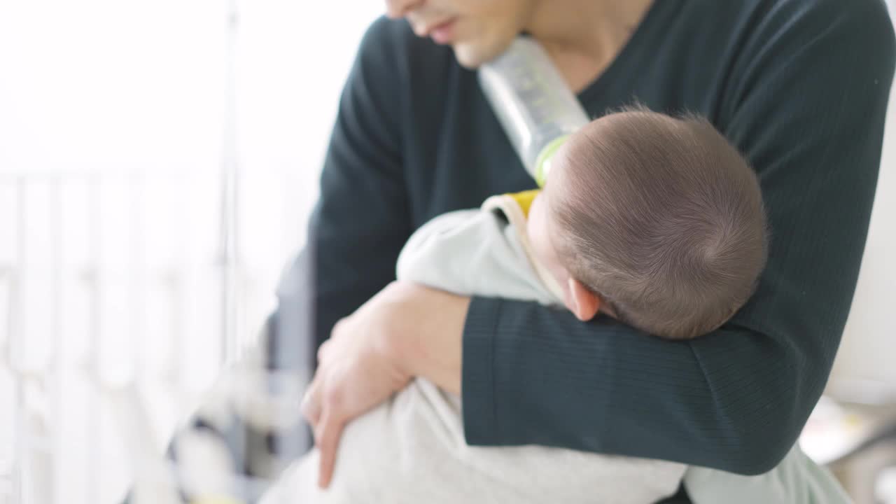 亚洲男子一边照顾孩子一边做家务视频下载