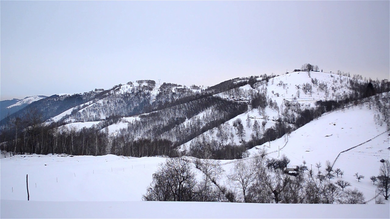 冬季的景观，山丘被森林和大量的雪覆盖视频素材